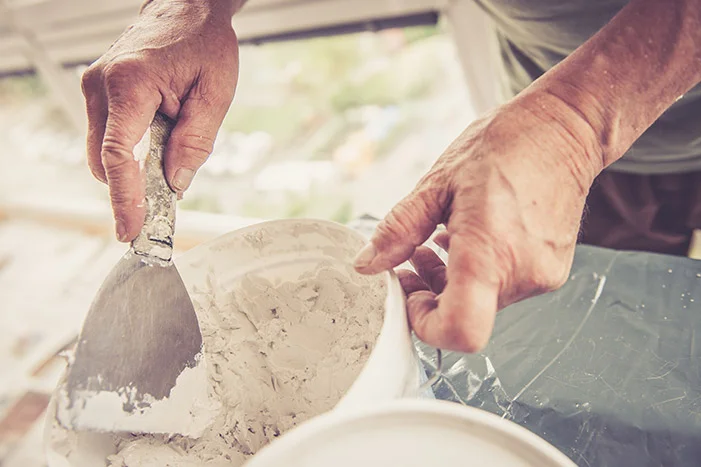 Person trägt Spachtelmasse auf